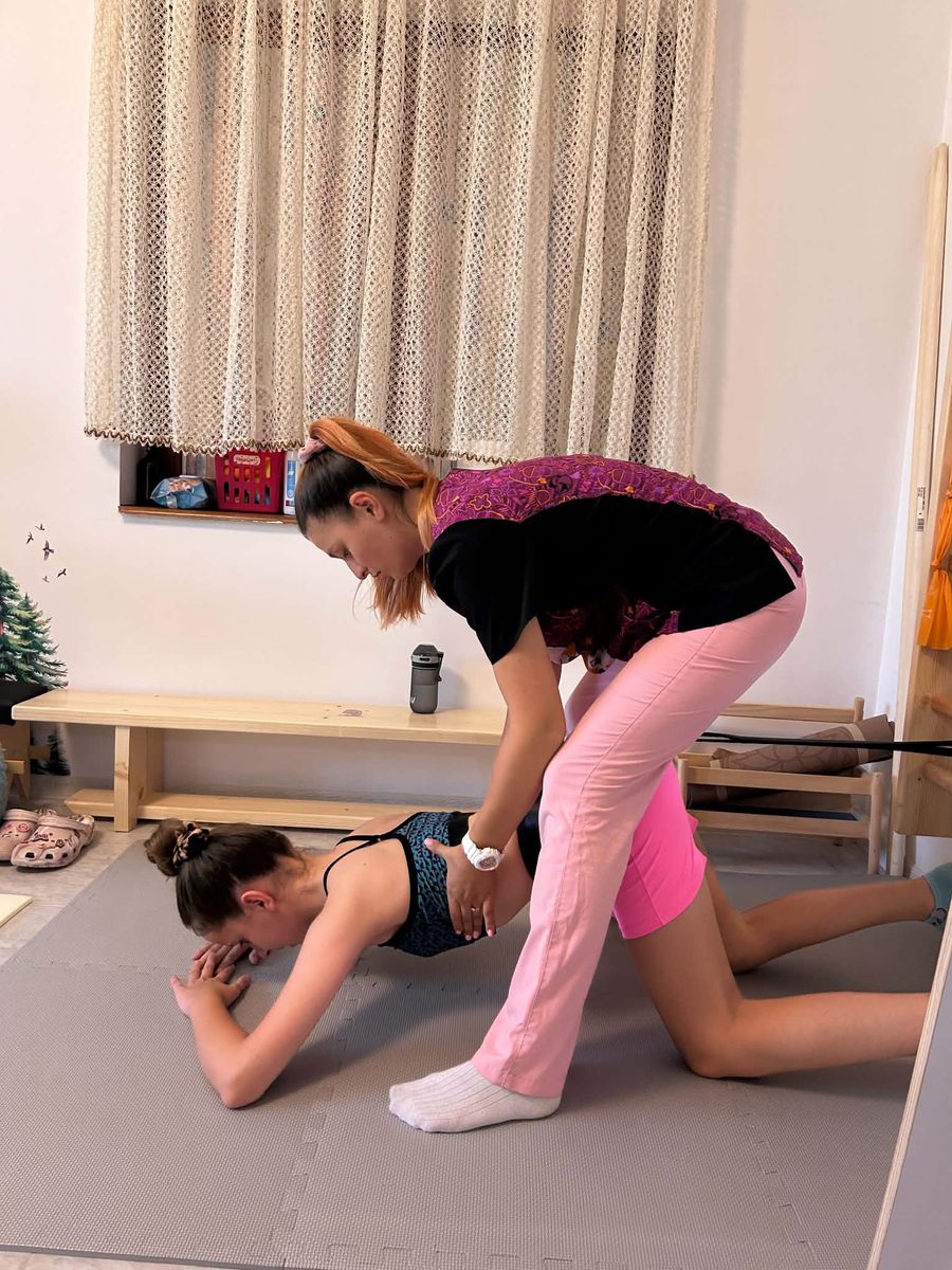 Exercițiu de terapie Schroth cu o adolescentă, corectat de kinetoterapeut